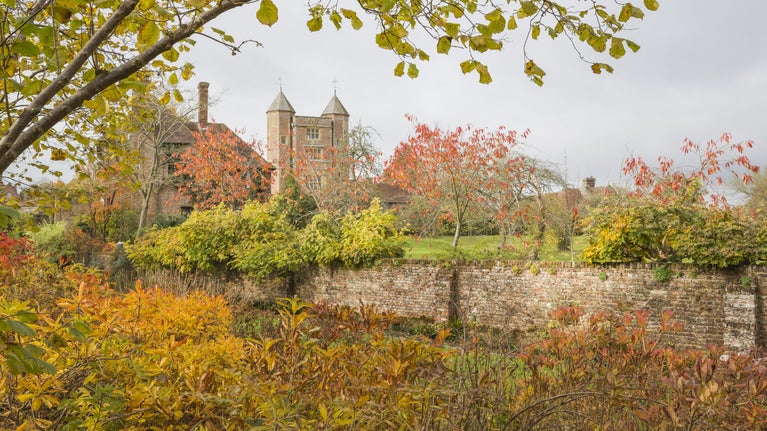 A view of the Elizabethan gatehouse tower from the autumnal gardens at Sissinghurst Castle Garden, Kent